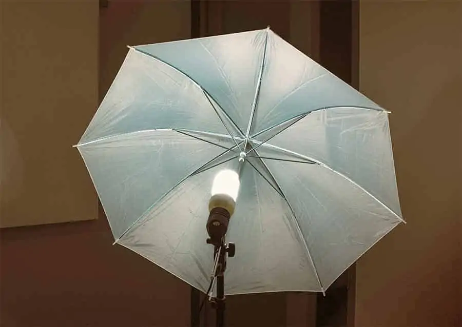 Umbrella light with spiral fluorescent light bulb mounted on a light stand. One of the four different types of photography umbrellas.