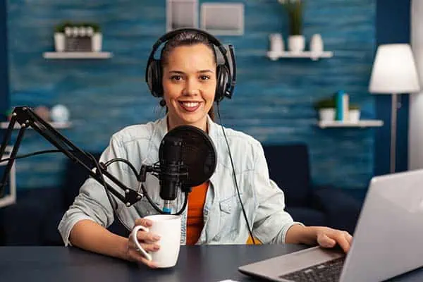 Young woman recording a podcast in a home studio