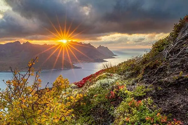 Example of sunburst at sunset using both a cloud and mountain to block part of the sun's disk