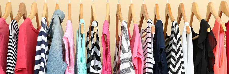 A rack of ladies tops and dresses that are made from light material that would be suitable under hot studio lights