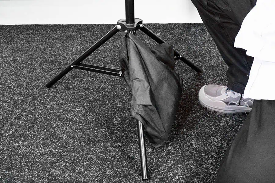 Correct sandbag placement hanging just above floor on light stand leg